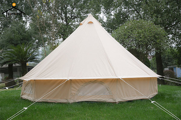 The tent is supported by one or more poles in the center and has guy cables that can be fastened to the ground for extra stability in windy conditions.